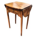 An oval walnut occasional table with drop leaves, the frieze with drawer and shaped apron, raised on