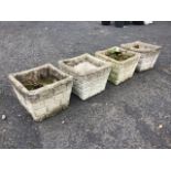 A set of four square composition stone garden pots cast with roughcast brick sides beneath tubular