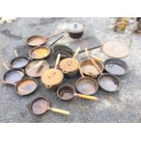 A collection of cast iron cooking pots and pans including antique skillets, graduated sets of