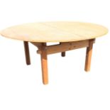 A contemporary pine rustic demountable table, the circular folding top with piano hinge above a