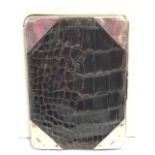 A crocodile skin wallet with silk and leather interior, having hallmarked silver mounted corners -