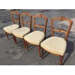 A set of four Victorian walnut chairs, the scrolling foliate carved crest rails above backs with
