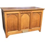 An oak altar, the rectangular cabinet with arched moulded panels, mounted with brass plaque dated