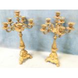 A pair of brass candelabra with six fluted urn shaped candleholders on scrolled branches supported