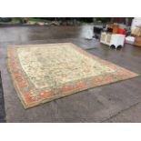 An Oushak style wool carpet, the cream field with an allover scrolling floral pattern, within formal