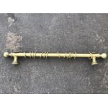 A contemporary gilt curtain pole with rings, having turned ball finials and wall supports. (Approx