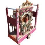 A fairground organ mounted on later trolley stand, the instrument with central carved automaton