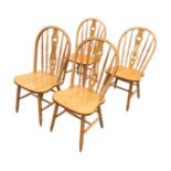 A set of four hardwood windsor style chairs with hooped arched backs above pierced splats and ring-