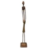 A Giacometti style African lost wax cast bronze elongated female figure, on square stepped