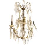 A hanging chandelier with six scrolled branches supporting candlelights and crystal drops around a