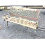 A rectangular cast iron garden bench with interlaced metal panel to back above a slatted seat, the