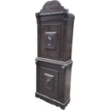 A nineteenth century Dutch carved oak cupboard with scrolled crest above cabinets having fielded