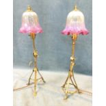 A near pair of Benson style brass tablelamps with cranberry wave rimmed glass shades on adjustable