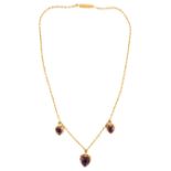 A 15ct gold necklace, the fine linked chain set with three heart shaped amethysts in beaded frames.