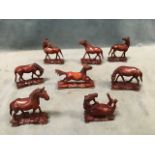 A set of eight Chinese hardwood horses carved out of the solid in various poses on naturalistic