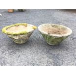 A pair of circular ribbed tapering composition stone garden pots. (18in) (2)