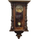 A Victorian walnut cased Vienna wallclock, with moulded cornice above an arched glazed door
