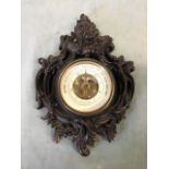 A 19th century French bois durci cartel barometer, the scrolling rococo style case enclosing an