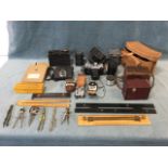 A collection of photographic equipment including a Russian Zenit SLR camera, a box Brownie,
