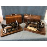 An oak cased Vickers sewing machine with gilt decoration to cast iron body; and a similar later