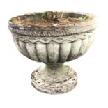 A large composition stone garden urn with ropetwist rim and fluted body on circular moulded