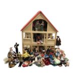 A large wood red-roofed dolls house in two parts with sliding doors and windows, with bedroom,