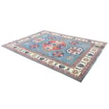 A Heriz carpet, the blue field with stylised floral medallions within scrolling foliate and