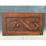 A Victorian carved mahogany panel with gryphon type bird and stylised scrolled foliage on pounced