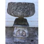 A composition stone garden urn cast with acanthus, on a square foot, raised on a shell and anthemion