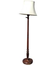 A mahogany standard lamp, the turned and fluted column on a moulded circular base raised on block