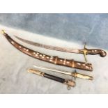 A replica World War II Japanese naval dagger, the brass and faux ivory hilt with floral mounts