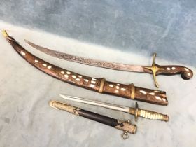 A replica World War II Japanese naval dagger, the brass and faux ivory hilt with floral mounts