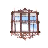 A set of Victorian mahogany hanging wall shelves, the fretwork back set with six bevelled mirrors,