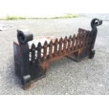 A rectangular firegrate with tapering slatted burning platform fronted by riveted grill rail,