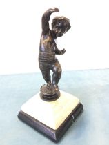 A nineteenth century bronze cherub with black patination, the boy with raised hand standing on