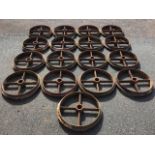 A set of seventeen cast iron wheels, each with moulded rims and four chamfered spokes around 3.5in