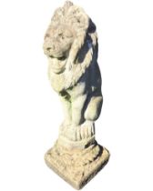 A composition stone garden figure of a seated lion, on a square plinth. (29in)