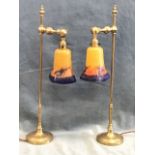 A pair of brass arts and crafts style tablelamps, the columns with turned finials above adjustable