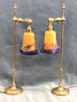 A pair of brass arts and crafts style tablelamps, the columns with turned finials above adjustable