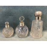 Three cut glass scent bottles with hallmarked silver collars, one London 1915, one with a repoussé