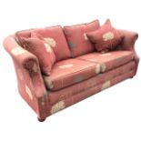 An upholstered two-seater cottage sofa with rounded back and loose cushions above a sprung seat,