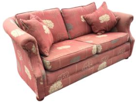 An upholstered two-seater cottage sofa with rounded back and loose cushions above a sprung seat,