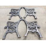 Two pairs of cast iron bench ends with scrolled arms on chanelled sabre legs. (4)