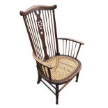 An Edwardian beech windsor style armchair, the shaped crestrail above a comb back with central wheel