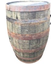 A large oak whiskey barrel, the staves bound by six riveted metal strap bands. (35in)