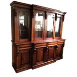 A reproduction Victorian mahogany breakfront bookcase with moulded cornice above four glazed doors