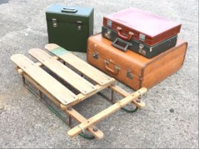 A C20th sledge with hardwood slatted frame, raised on tubular rails; a green faux-leather