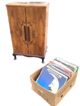 A walnut cabinet with moulded top above two doors enclosing record compartments and a JVC stereo