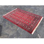 A Turkoman rug, the red ground with three rows of gul motifs interspersed with hooked diamond