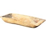 A large ancient sycamore trug adzed out of a solid log, the boat shaped bowl with angled ends. (